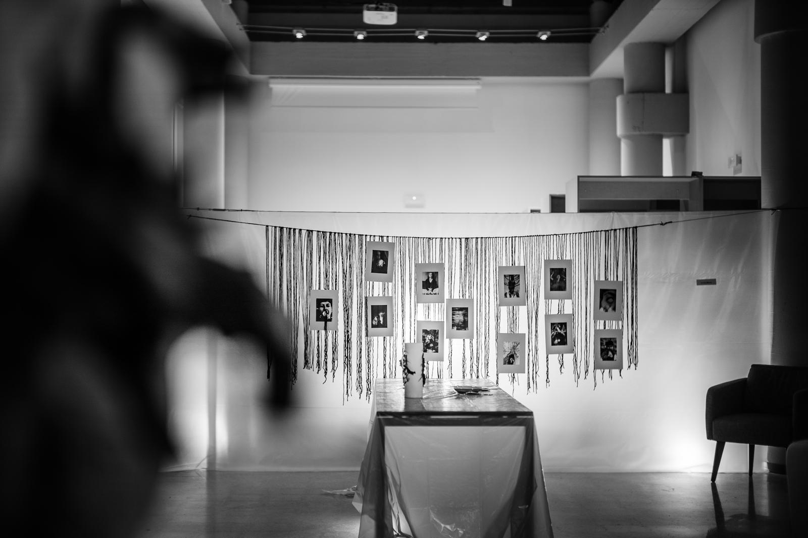 Installazione con fili neri e polaroid