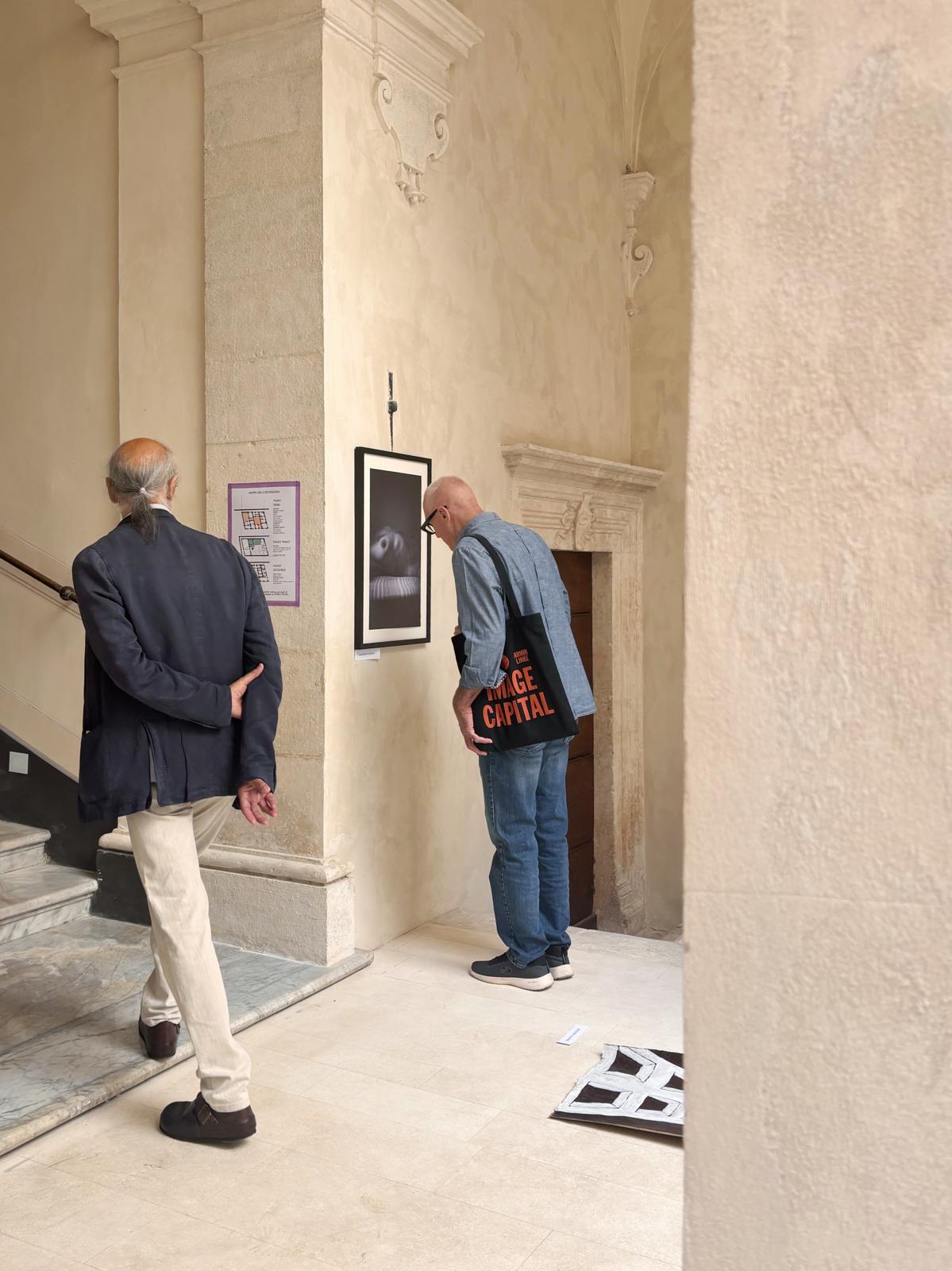 Visitatori osservano una fotografia in cornice