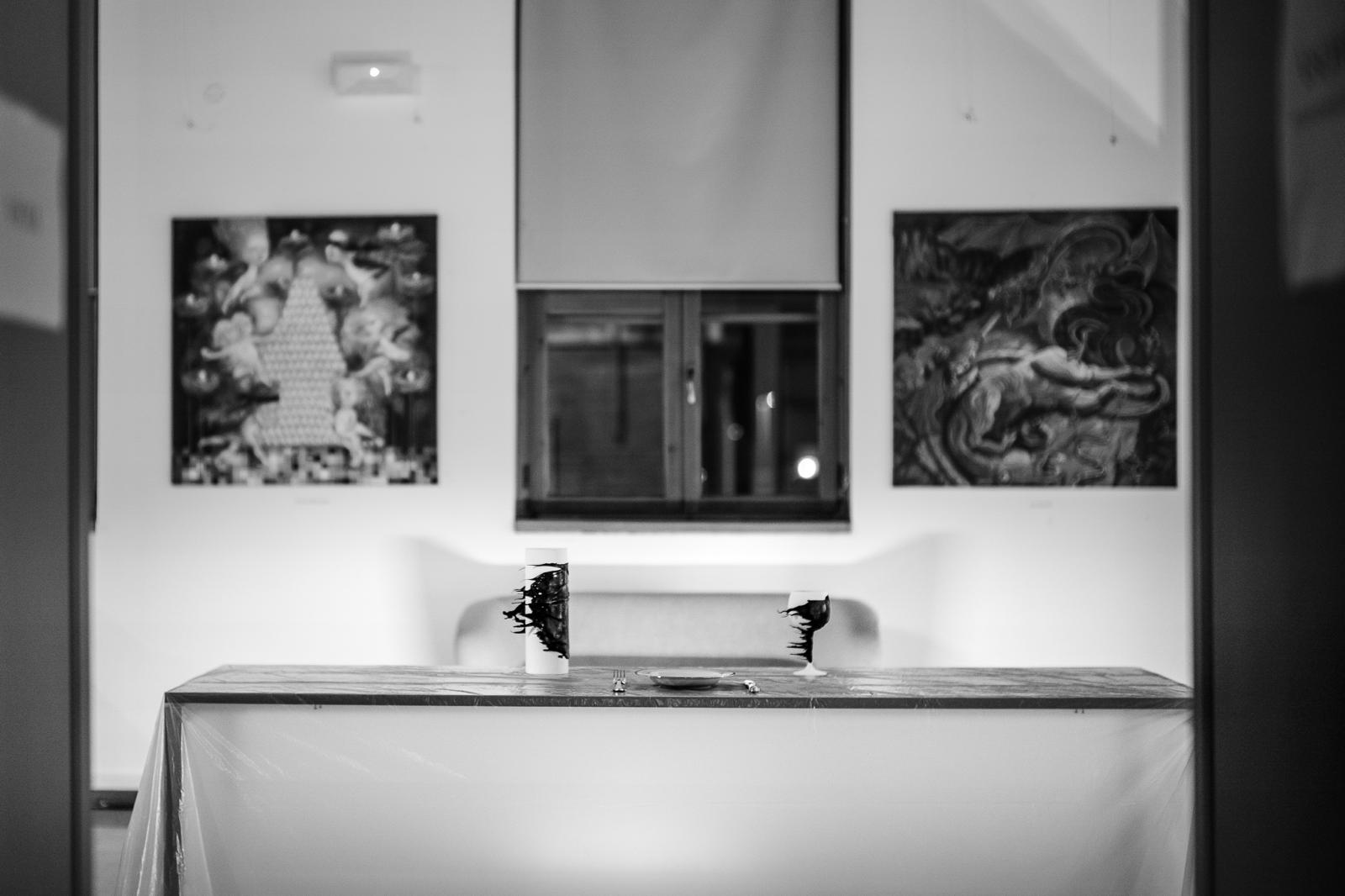 Sala espositiva con tavola e dipinti