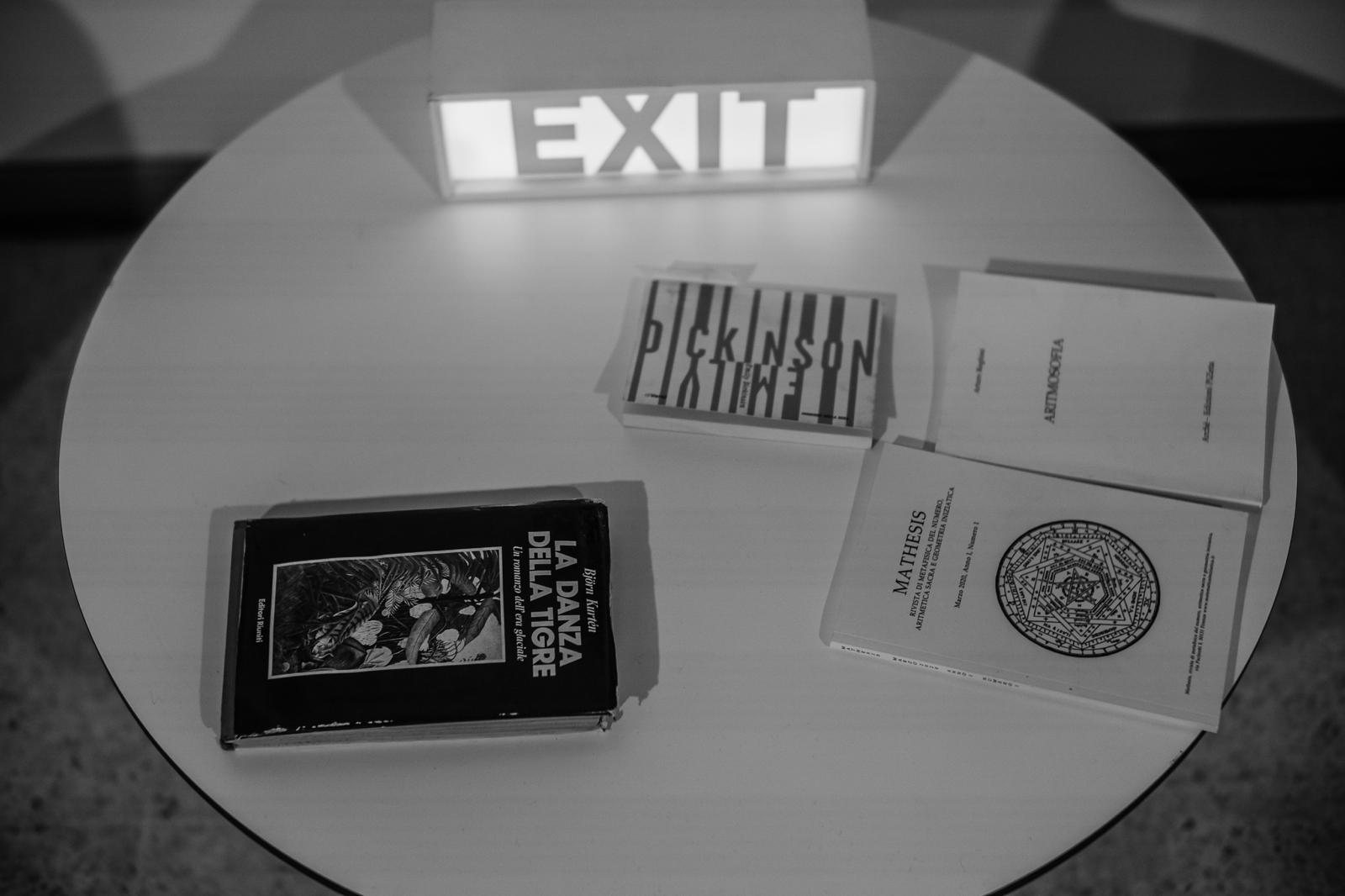 Libri e insegna EXIT su tavolo rotondo